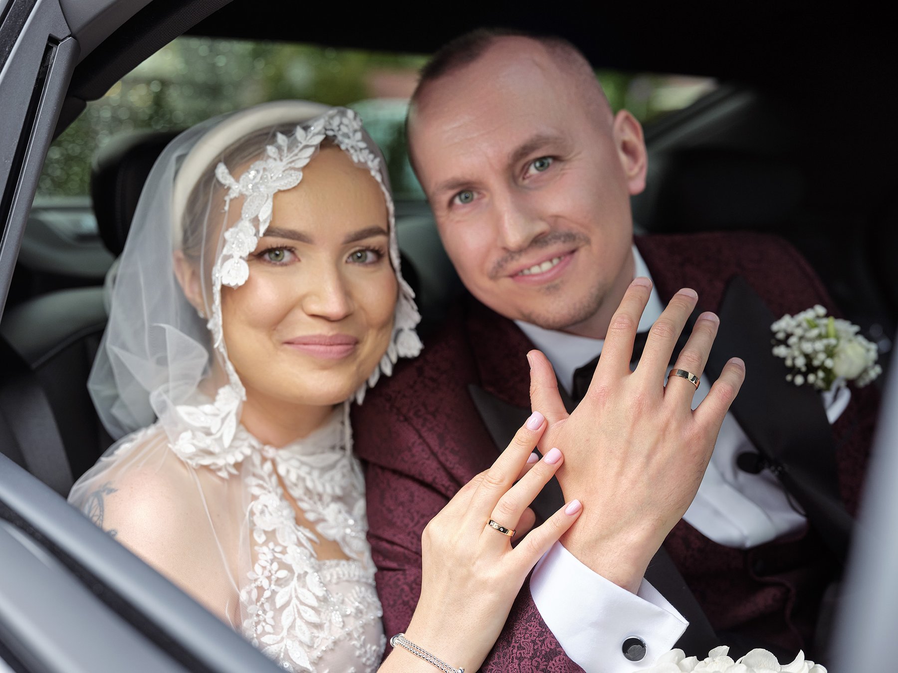 Para młoda po ceremonii przy aucie ślubnym